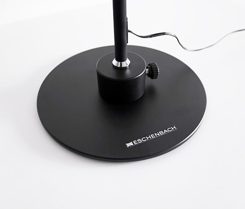 base of the Magno Lumina Max Desk Lamp base of lamp. This corded lamp features a black flexible neck and weighted base, allowing users to adjust the optimal position for viewing. It offers adjustable light color temperature and brightness level settings to create an ideal viewing environment. Available in both desktop and floor versions, this lamp provides superior illumination. For people with low vision, its customizable lighting and flexible design make it a practical and accessible solution
