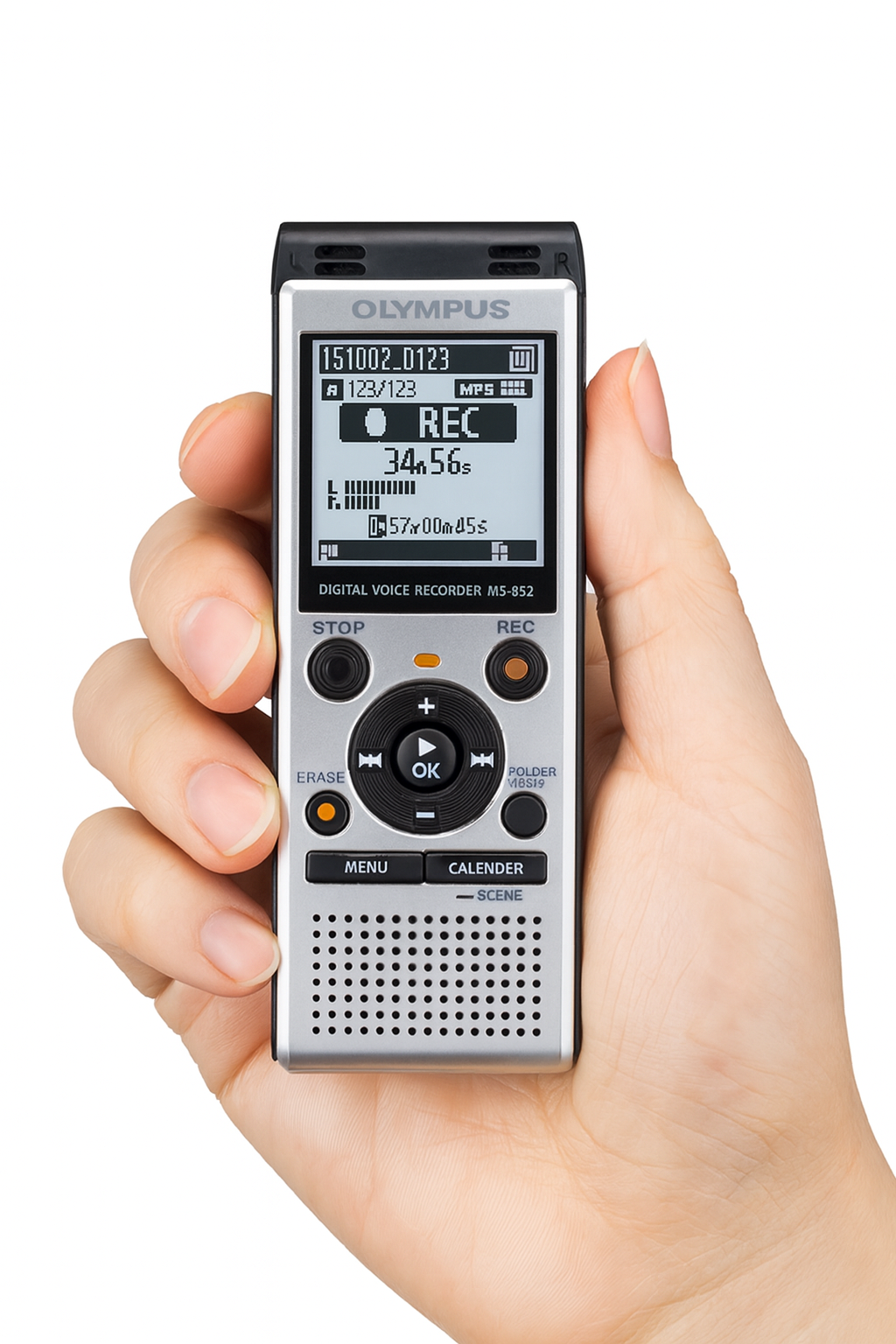 A close-up of a person’s hand holding the Olympus WS-852 digital voice recorder vertically against a plain white background. The recorder is silver with black accents and features a clear display screen showing a recording in progress with a timer, audio level indicators, and file information. Below the screen, the front panel includes buttons labeled STOP, REC, ERASE, FOLDER/INDEX, MENU, CALENDER, and SCENE, along with a central circular navigation pad and built-in speaker grille. The hand is positioned na